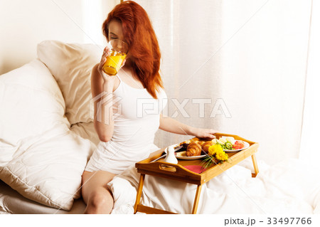 Young woman eats breakfast in bed in the morning. Young woman eats breakfast in bed in the morning. 33497766
