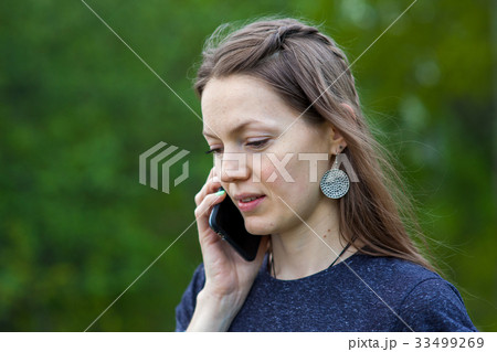smiling girl speaks by mobile phone against summer smiling girl speaks by mobile phone against summer 33499269