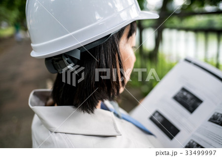 資料を読む女性作業員 資料を読む女性作業員 33499997