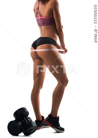 Beautiful sportswoman measuring her hips Beautiful sportswoman measuring her hips 33500030