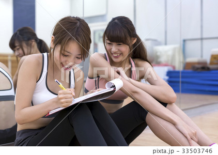 フィットネスジム　トレーニング内容を確認する若い女性 33503746