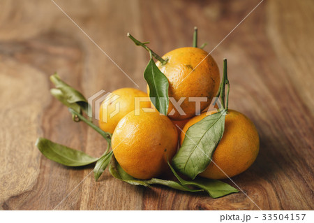 organic tangerines with leaves on wood table organic tangerines with leaves on wood table 33504157