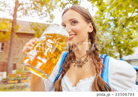 Woman wearing Dirndl drinking beer  33506793