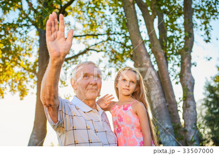 Girl with grandfather waving hands. 33507000