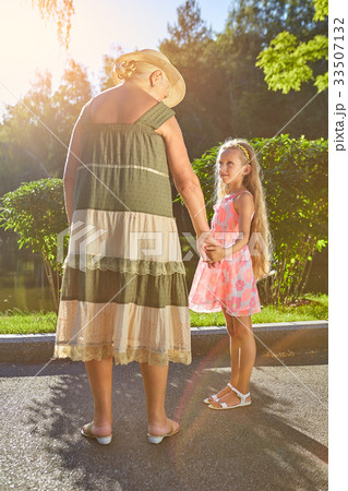 Girl with her granny outdoors. 33507132