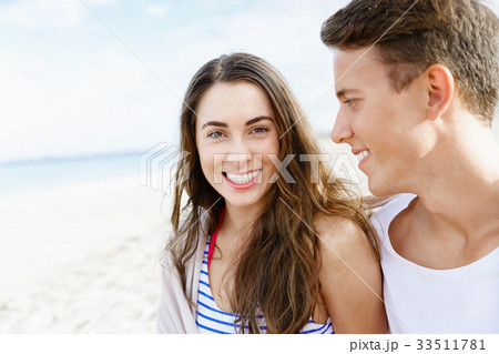 Romantic young couple sitting on the beach 33511781