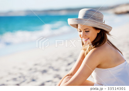 Young woman sitting on the beach Young woman sitting on the beach 33514301