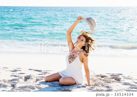 Young woman sitting on the beach Young woman sitting on the beach 33514334