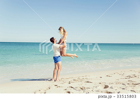 Happy couple jumping on beach vacations 33515803