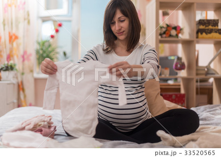 Pregnant woman with big belly at home 33520565