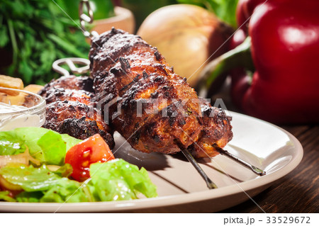 Grilled shish kebab served with fried chips 33529672