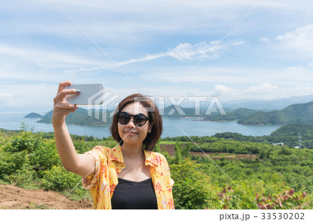 Female traveler selfie with her smart phone Female traveler selfie with her smart phone 33530202