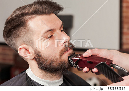 Hipster client visiting barber shop Hipster client visiting barber shop 33533515