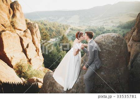 Gorgeous bride and stylish groom walking at sunny Gorgeous bride and stylish groom walking at sunny 33535781