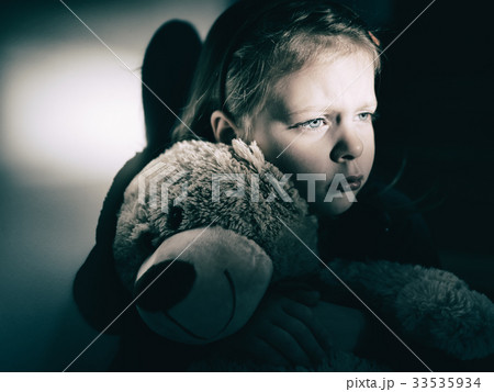 Sad little girl embracing her teddy bear 33535934