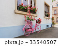 A decorative old pink bicycle with a flower basket 33540507