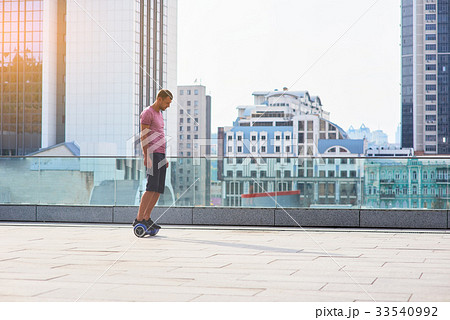 Man on hoverboard, city background. Man on hoverboard, city background. 33540992