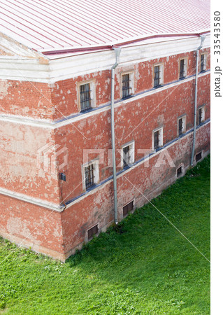 wall of prison with barred windows 33543580