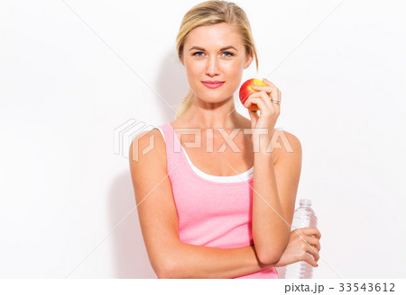 Happy young woman holding apple and water Happy young woman holding apple and water 33543612