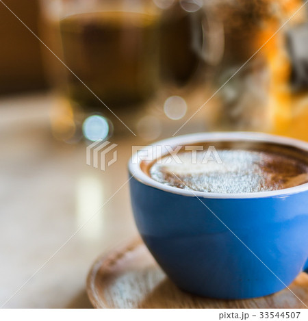 Close up coffee cup with steam on table in cafe. Close up coffee cup with steam on table in cafe. 33544507