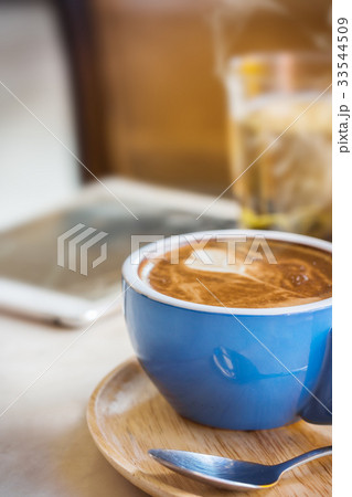 Close up coffee cup with steam on table in cafe. Close up coffee cup with steam on table in cafe. 33544509