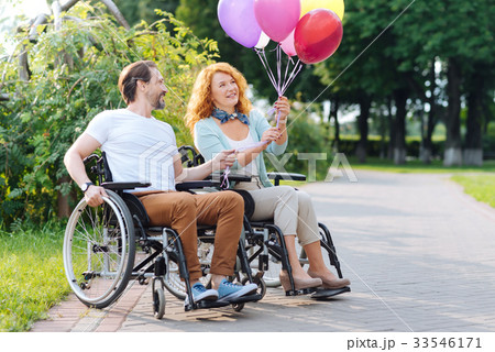 Joyful disabled couple holding balloons Joyful disabled couple holding balloons 33546171