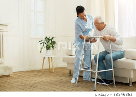 Delighted positive caregiver helping her patient Delighted positive caregiver helping her patient 33546862