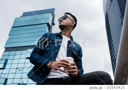 Young man wearing blue denim jacket while 33547415