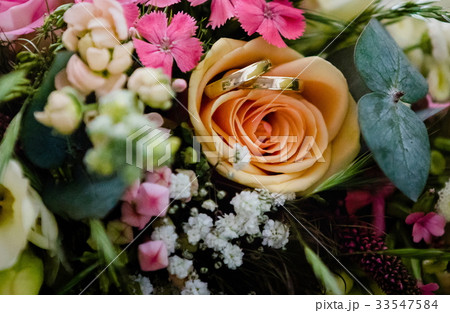 Wedding rings over a bouquet Wedding rings over a bouquet 33547584
