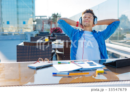 Joyful guy listening to music and relaxing Joyful guy listening to music and relaxing 33547679