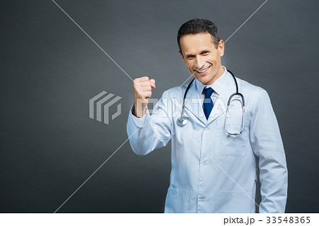 Excited male doctor gesturing while posing for Excited male doctor gesturing while posing for 33548365