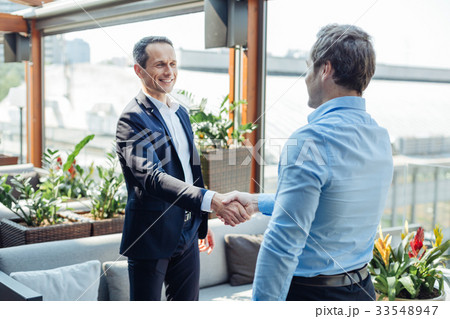Cheerful positive businessmen clenching a deal 33548947