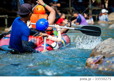 Young men and women are rafting on the river 33550275