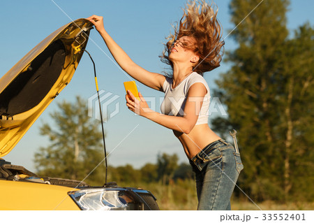 Girl repairing car and on phone Girl repairing car and on phone 33552401