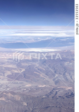 南米大陸を南北に縦断するアンデス山脈、チリ中部上空の雲間から見る初夏の高地山岳地帯と美しい塩湖 33553563