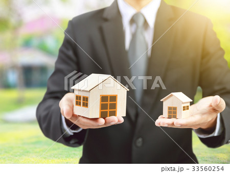 businessman hold big and small houses on hand 33560254
