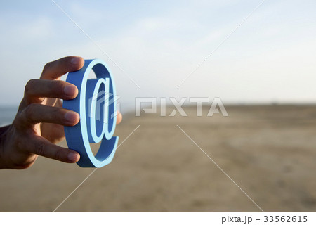 young man with an at sign in his hand 33562615