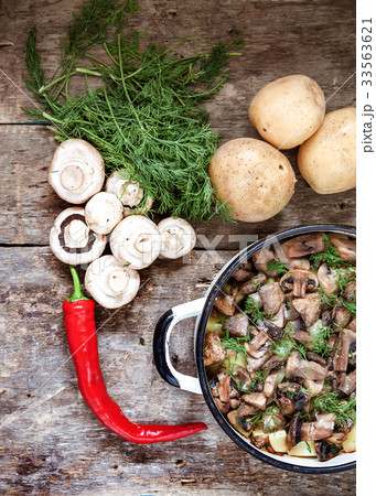 Dish of potatoes with mushrooms on a wooden Dish of potatoes with mushrooms on a wooden 33563621