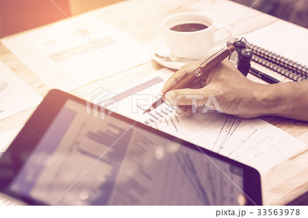 Hand businessman pointing on summary chart report Hand businessman pointing on summary chart report 33563978