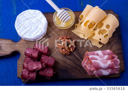 Cheese and meat plate with walnuts on blue wooden Cheese and meat plate with walnuts on blue wooden 33565618