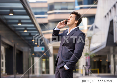 Portrait of confident businessman with mobile phone outdoors 33569391