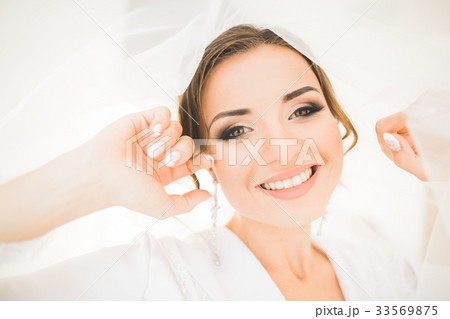 Gorgeous bride in robe posing and preparing for Gorgeous bride in robe posing and preparing for 33569875