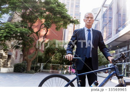 Successful businessman riding bicycle Successful businessman riding bicycle 33569965