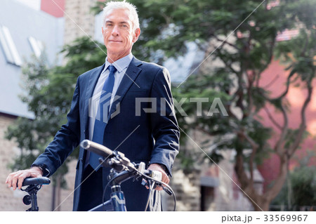 Successful businessman riding bicycle Successful businessman riding bicycle 33569967