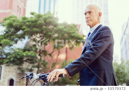 Successful businessman riding bicycle Successful businessman riding bicycle 33570372