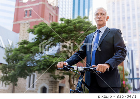 Successful businessman riding bicycle Successful businessman riding bicycle 33570471