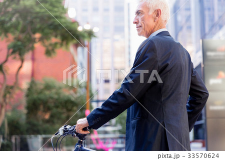 Successful businessman riding bicycle Successful businessman riding bicycle 33570624