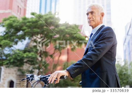 Successful businessman riding bicycle Successful businessman riding bicycle 33570639