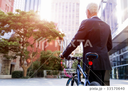 Successful businessman riding bicycle Successful businessman riding bicycle 33570640