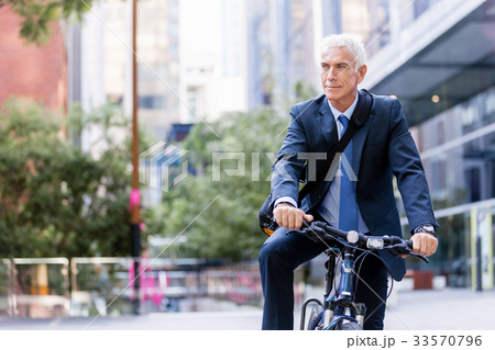 Successful businessman riding bicycle Successful businessman riding bicycle 33570796